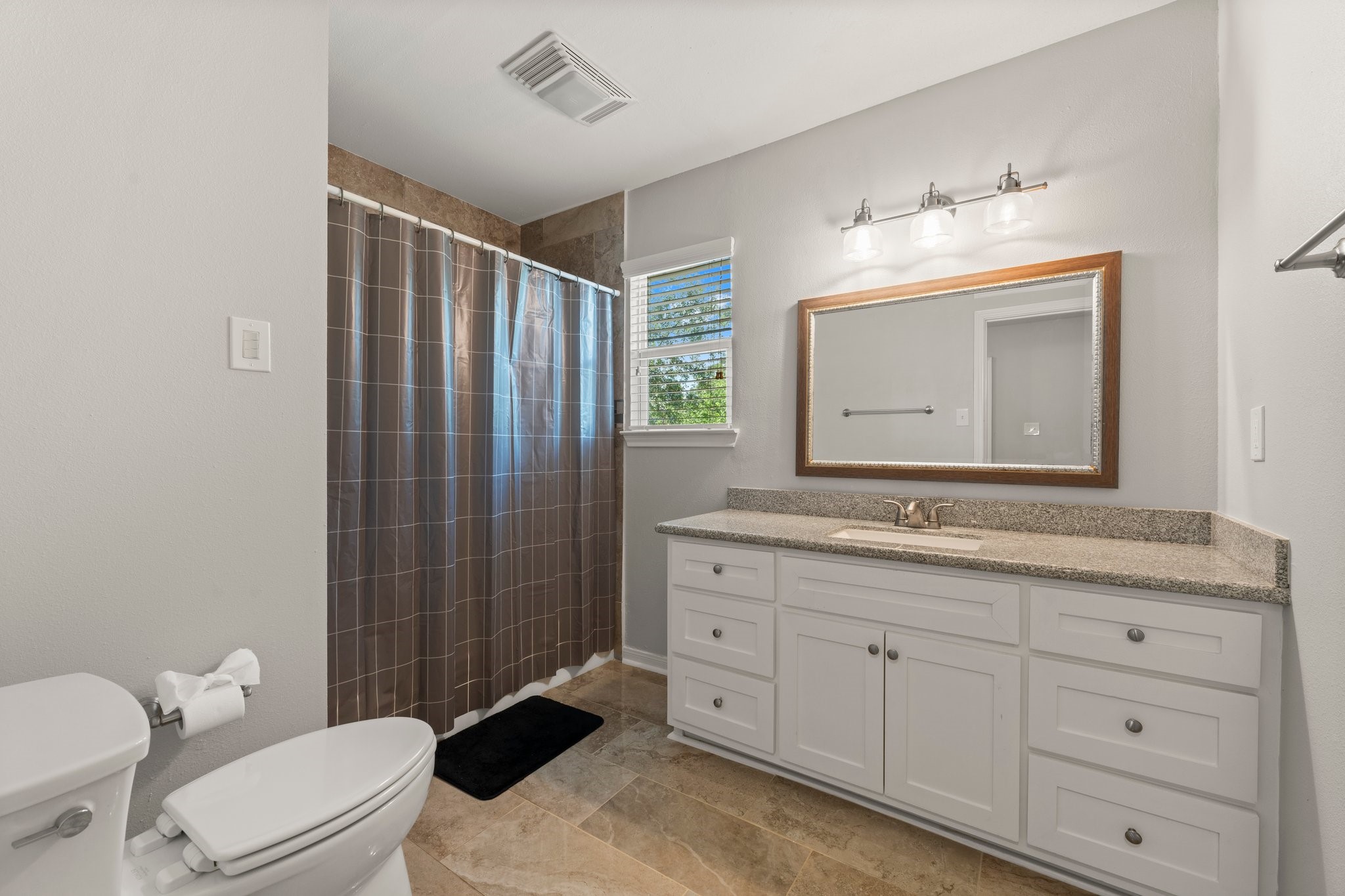 6030 Craigway Road Spring, TX 77389 - Photo 33 of 45 This bathroom features a modern design with a spacious vanity and ample cabinet space. It includes a walk-in shower with a large mirror and overhead lighting.