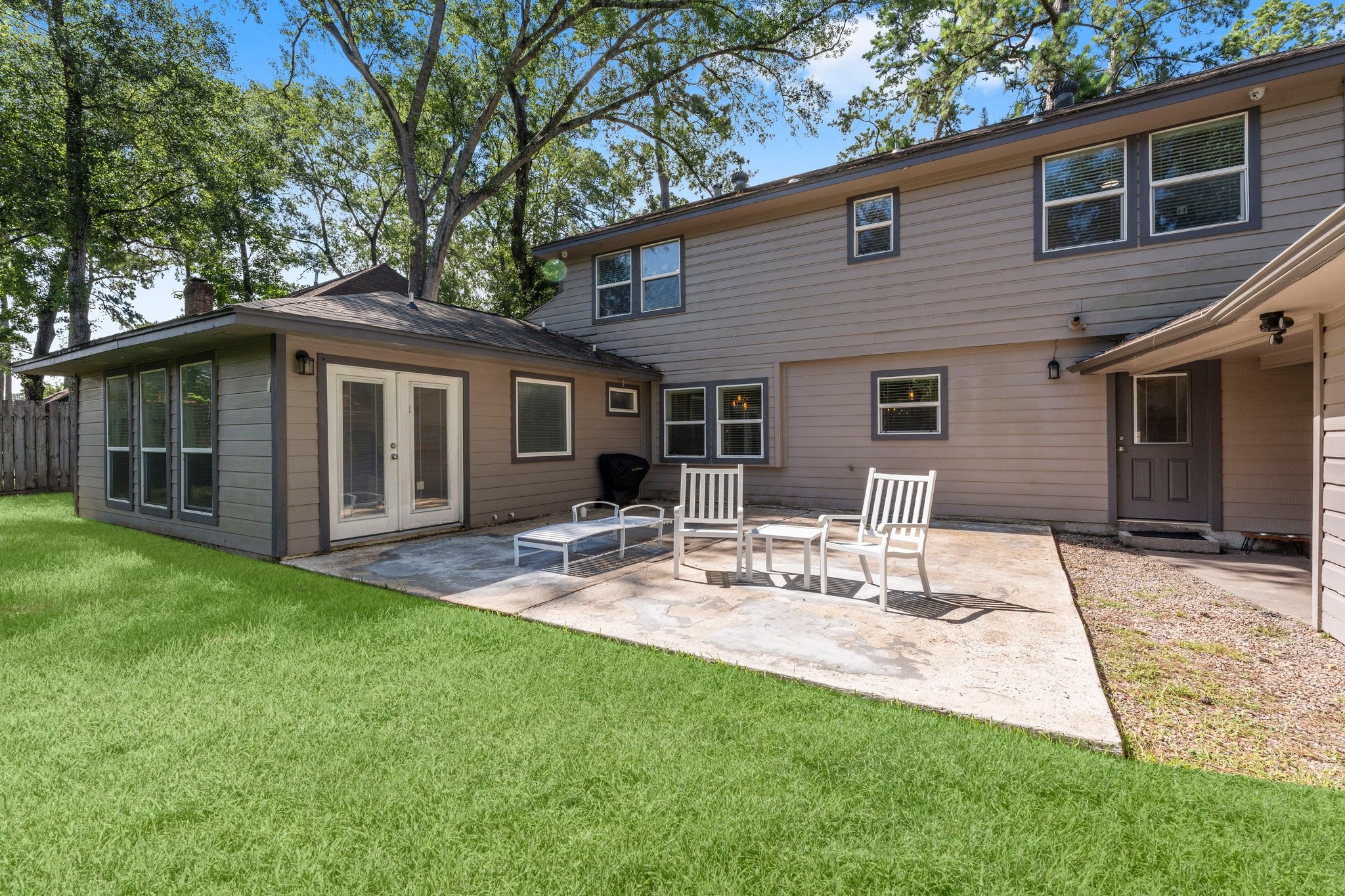 6030 Craigway Road Spring, TX 77389 - Photo 34 of 45 This photo showcases a spacious backyard featuring a well-maintained lawn and a concrete patio with seating.