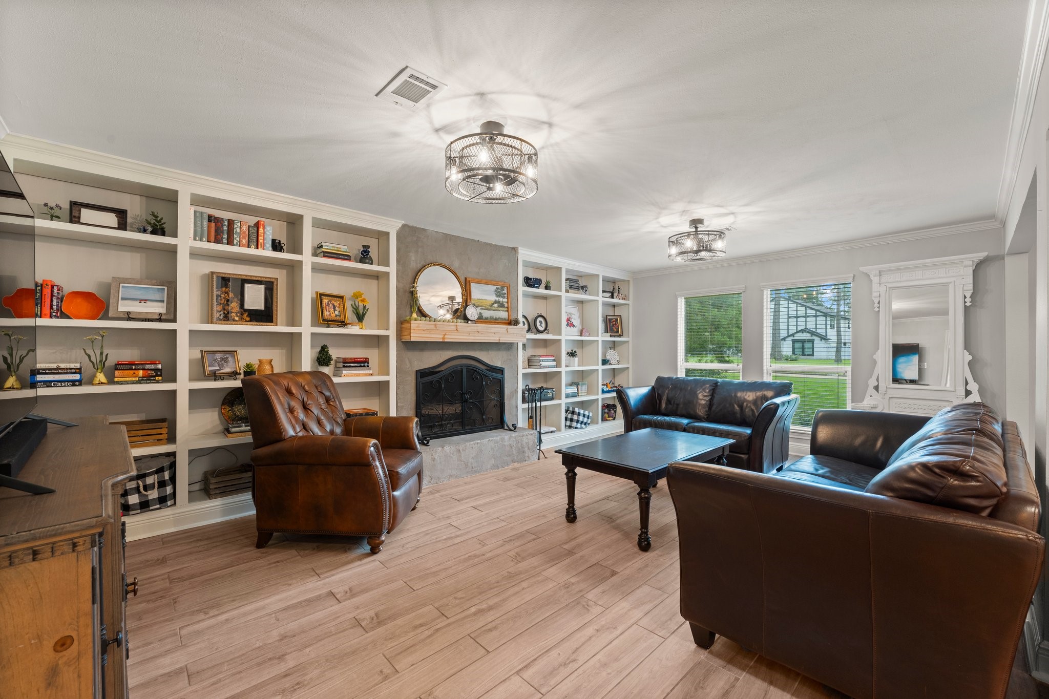 6030 Craigway Road Spring, TX 77389 - Photo 7 of 45 This living room features elegant built-in shelves and a cozy fireplace. Large windows provide ample natural light. Perfect for relaxation and entertaining.