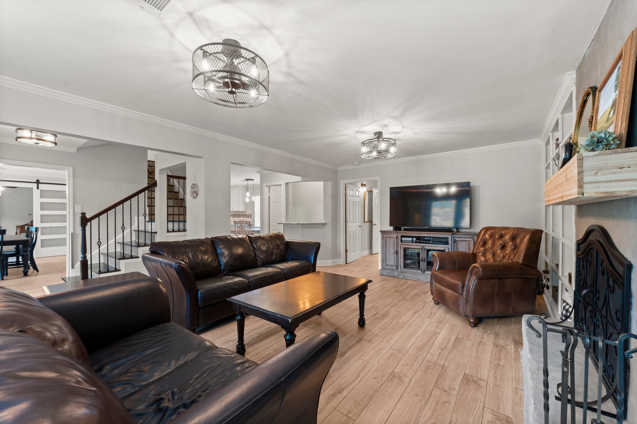 6030 Craigway Road Spring, TX 77389 - Photo 8 of 45 Living room features a cozy fireplace with a decorative mantel. The space is well-lit with an open view to the kitchen and dining area, creating a seamless flow for entertaining.