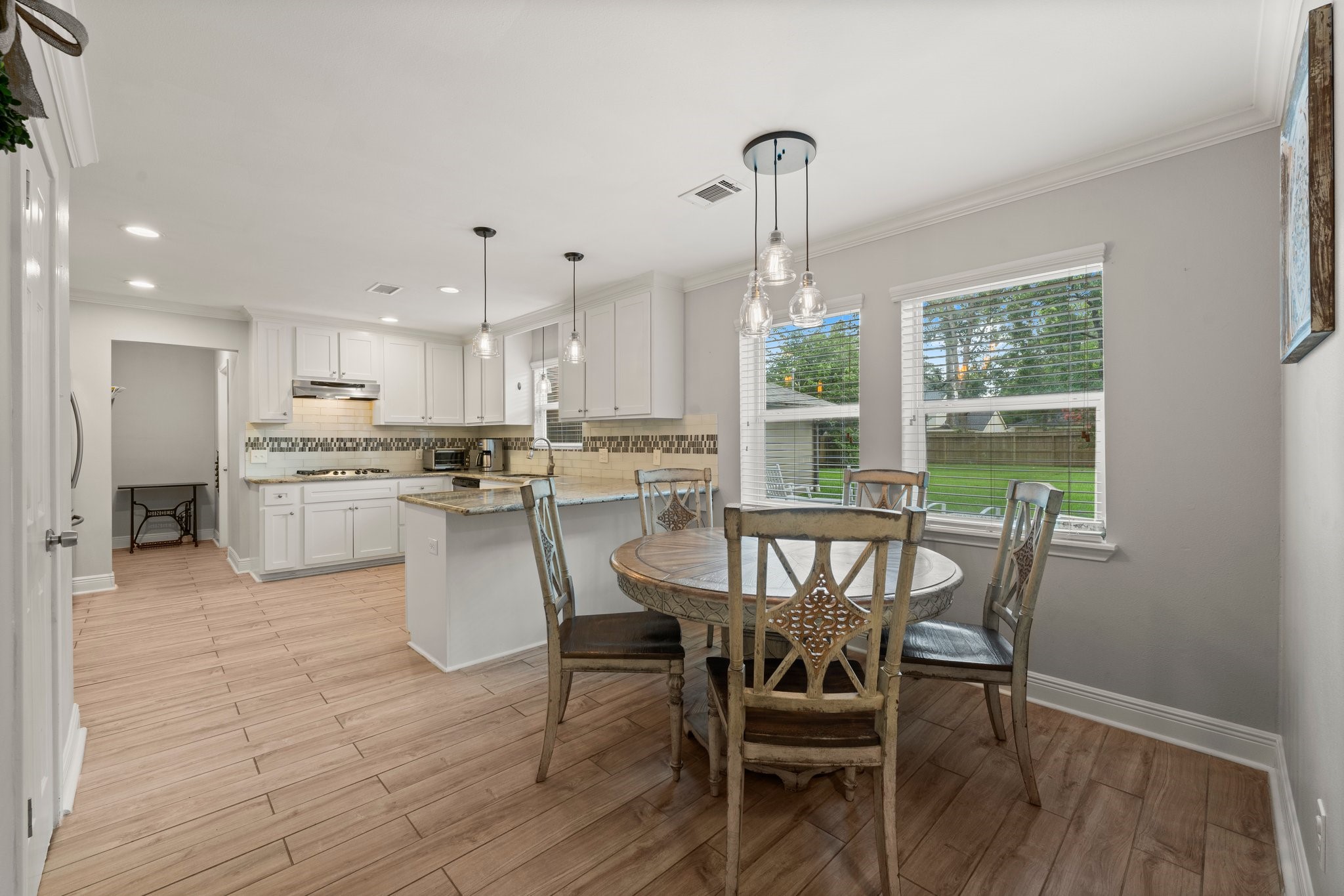 6030 Craigway Road Spring, TX 77389 - Photo 10 of 45 This photo showcases a bright, open-concept kitchen and dining area. It features large windows offering a view of the backyard.