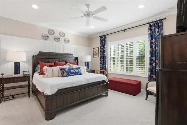 a bedroom with a bed dresser and a large window