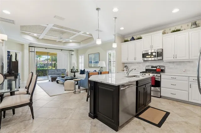 a kitchen with a stove a sink a dining table and chairs with wooden floor
