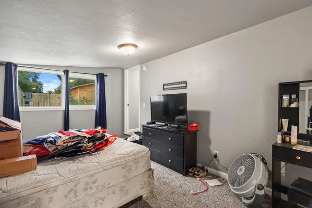 a bedroom with a bed and a flat screen tv