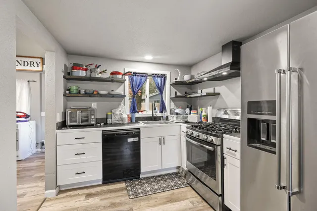a kitchen with stainless steel appliances granite countertop a stove and a refrigerator