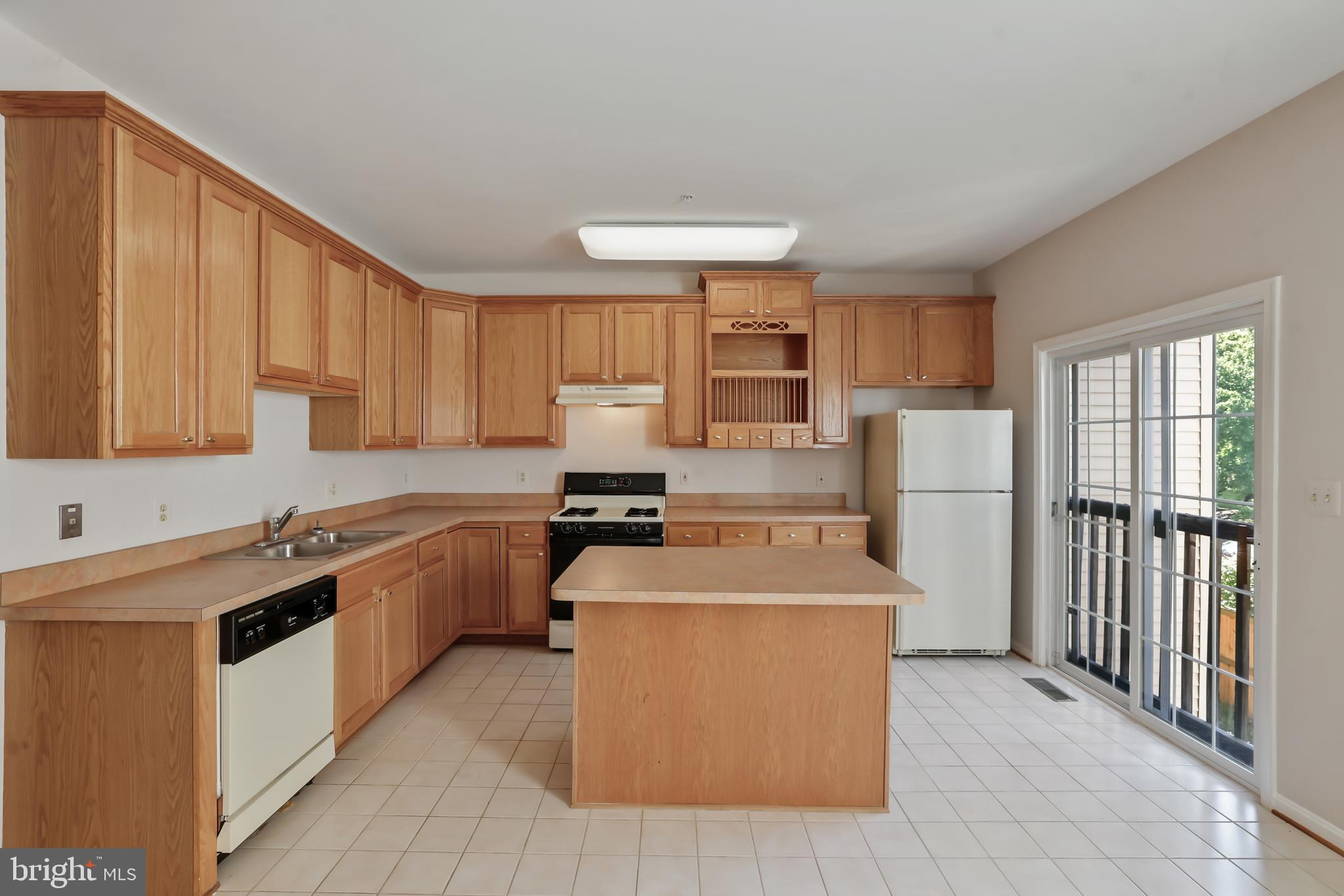 1802 Spanish Oak Lane Bowie, MD 20721 - Photo 10 of 53 a kitchen with stainless steel appliances granite countertop a stove top oven a sink dishwasher and a refrigerator with wooden cabinets