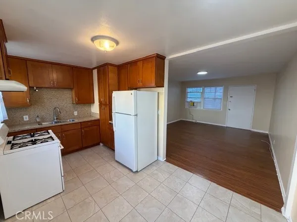 a kitchen with a refrigerator a stove top oven and cabinets