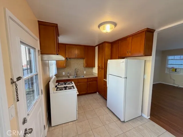 a kitchen with a refrigerator a stove top oven a sink and cabinets