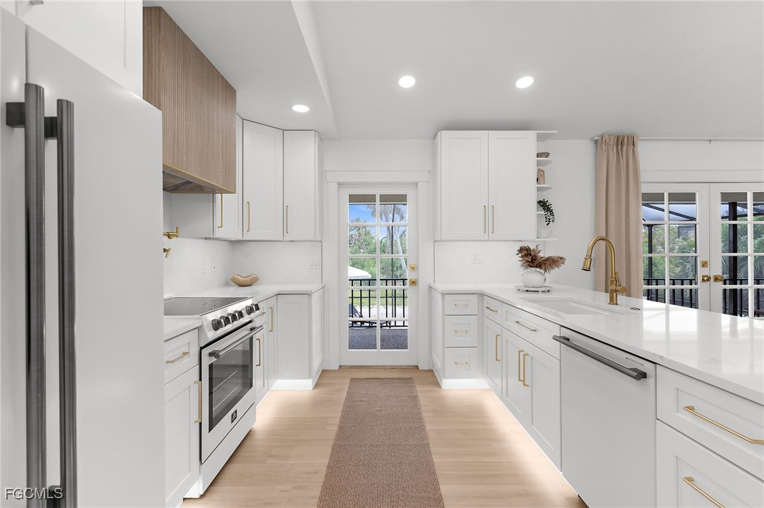 13270 Electron Drive Fort Myers, FL 33908 - Photo 13 of 47 a large kitchen with stainless steel appliances granite countertop a stove a sink and a refrigerator