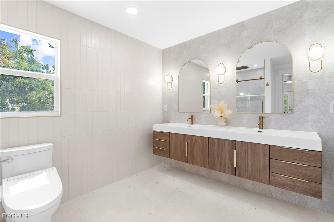13270 Electron Drive Fort Myers, FL 33908 - Photo 28 of 47 a spacious bathroom with a double vanity sink a mirror and a toilet
