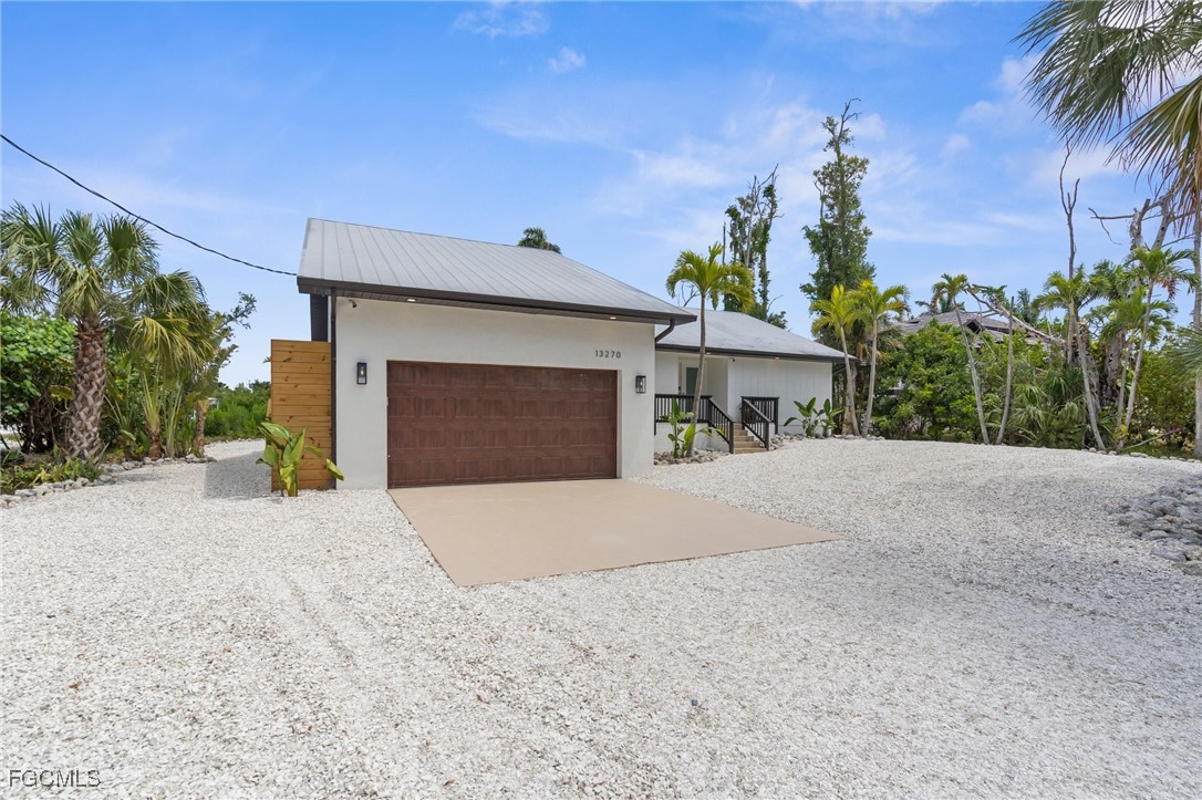 13270 Electron Drive Fort Myers, FL 33908 - Photo 4 of 47 a front view of a house with a yard and garage