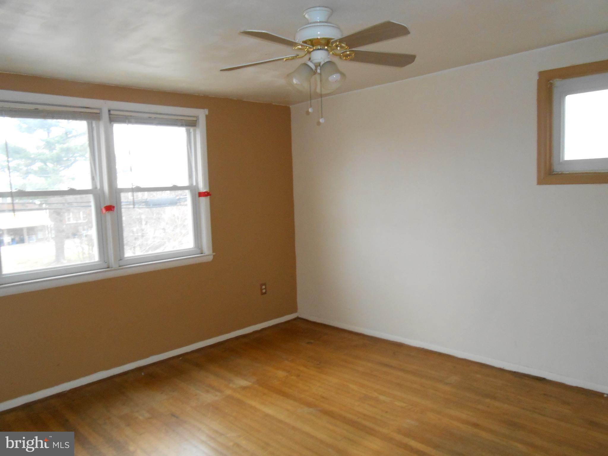 4211 Crest Heights Road Baltimore, MD 21215 - Photo 15 of 21 a view of an empty room with a window and wooden floor