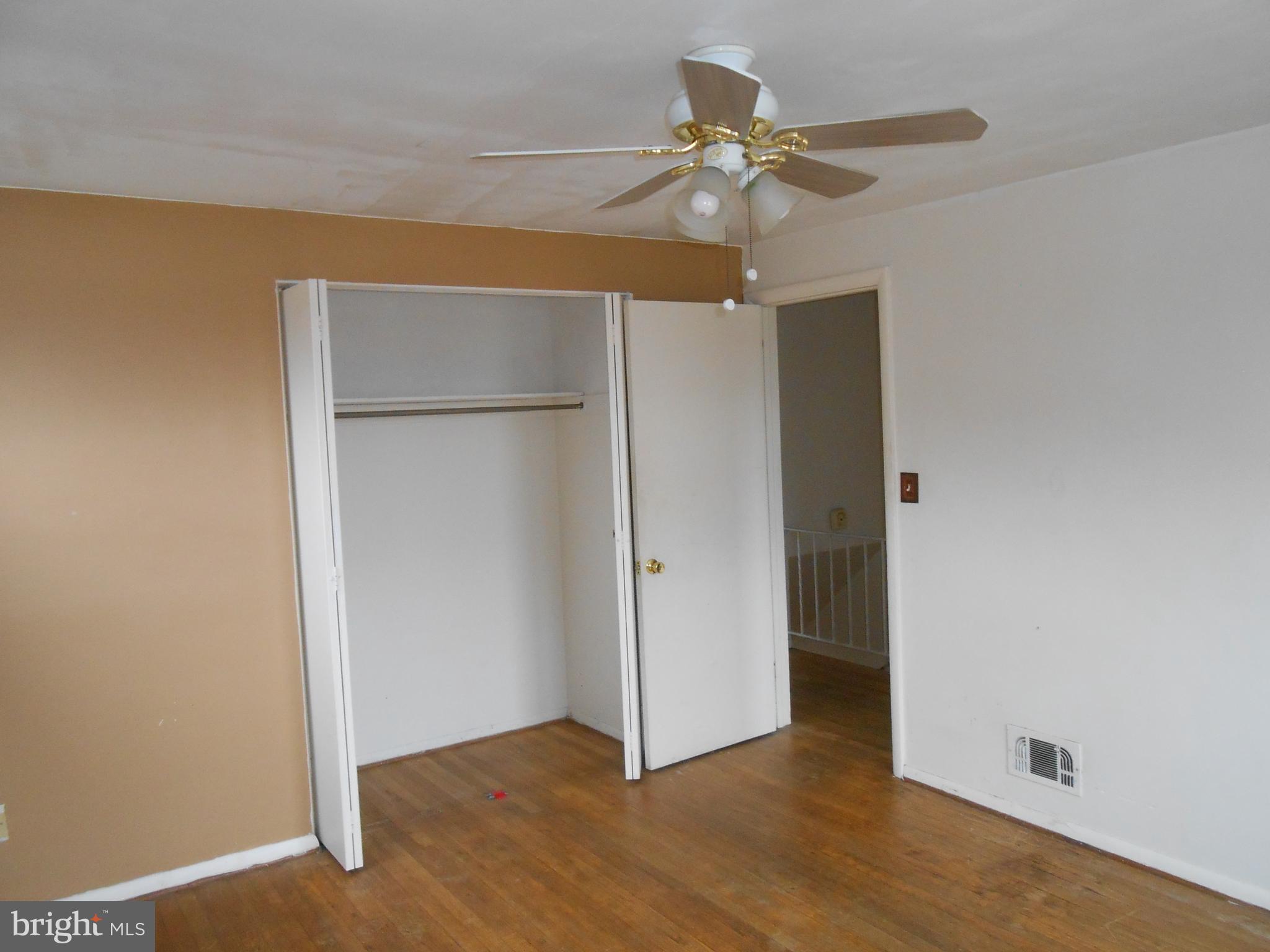 4211 Crest Heights Road Baltimore, MD 21215 - Photo 16 of 21 an empty room with wooden floor closet fan and windows