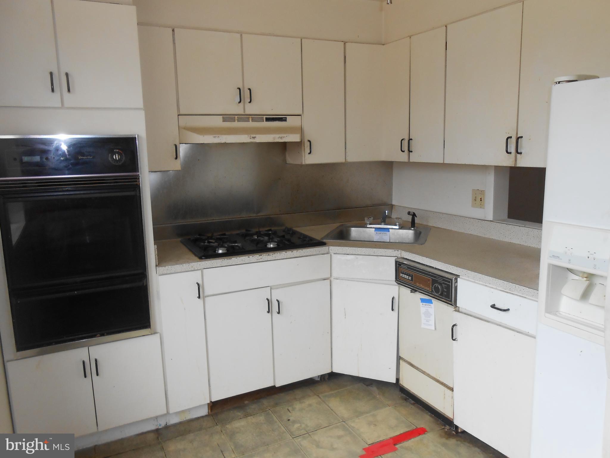 4211 Crest Heights Road Baltimore, MD 21215 - Photo 9 of 21 a kitchen with white cabinets and appliances