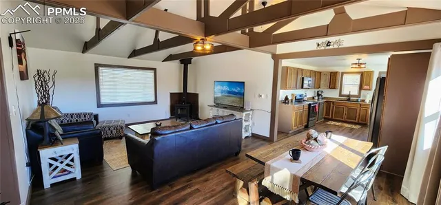 a living room with furniture a flat screen tv and kitchen view