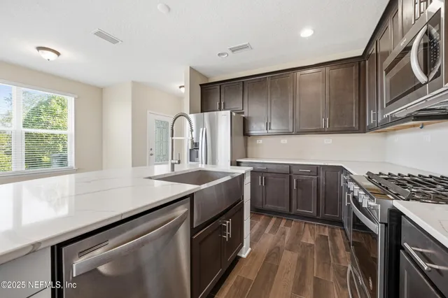 a kitchen with stainless steel appliances granite countertop a sink stove and refrigerator