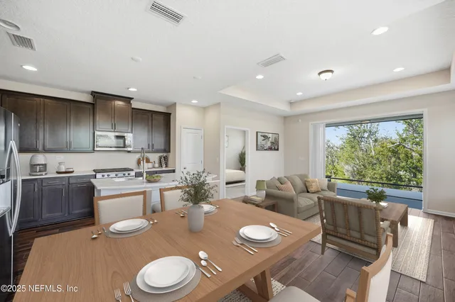 a open kitchen with stainless steel appliances granite countertop a stove and white cabinets