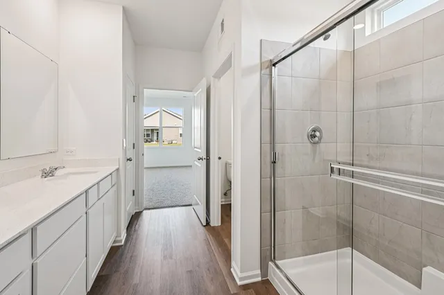 a bathroom with a double vanity sink and mirror with shower