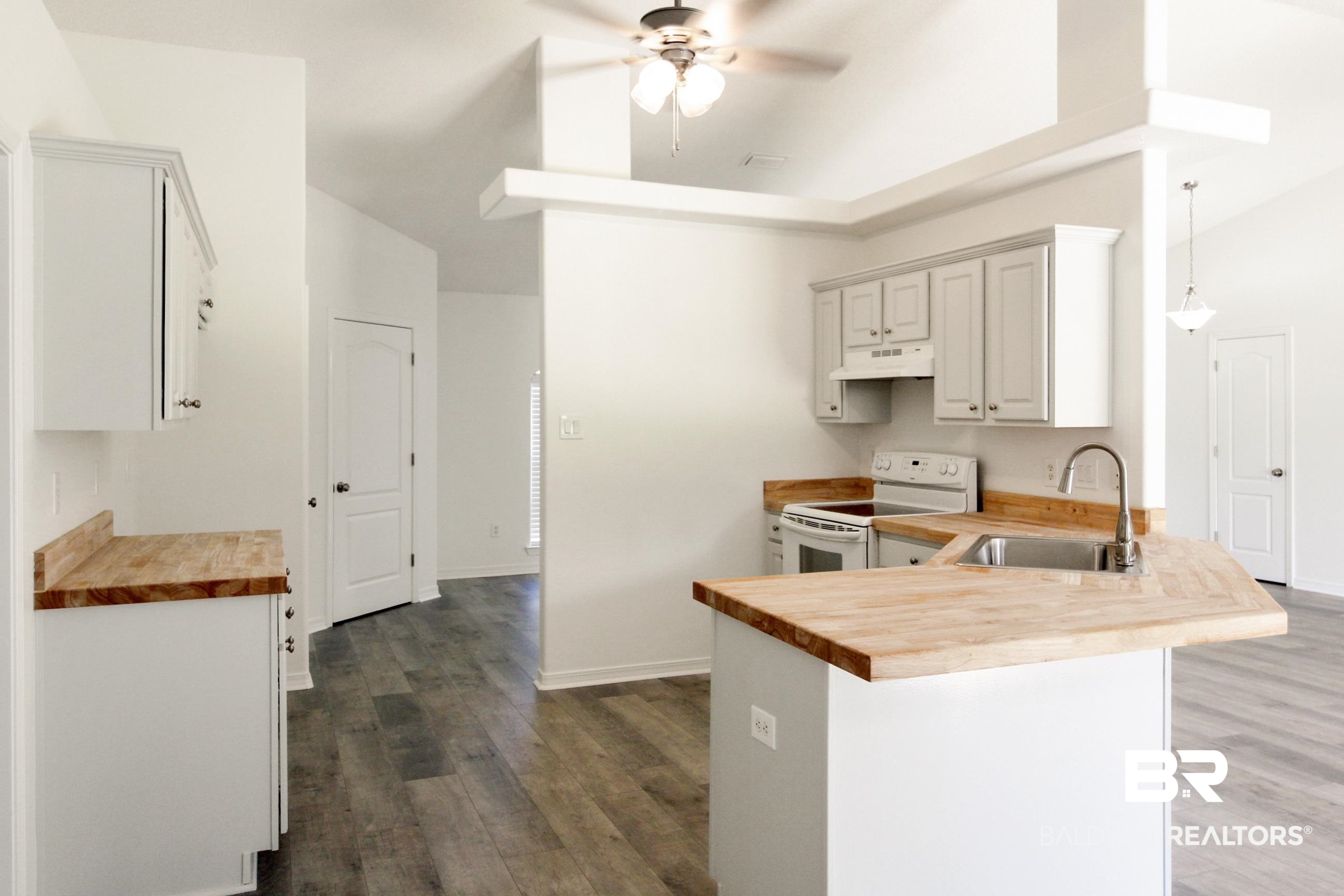 14750 Pawnee Court Foley, AL 36535 - Photo 17 of 34 Kitchen featuring butcher block counters, white electric stove, a peninsula, a ceiling fan, and high vaulted ceiling