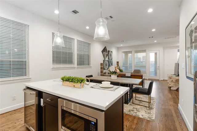 a kitchen with a table chairs stove and wooden floor