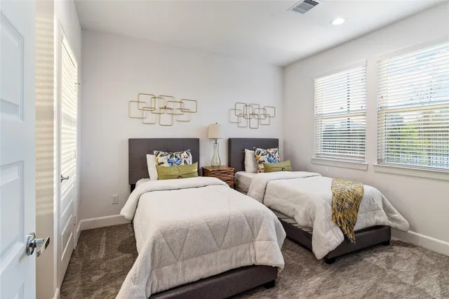 a spacious bedroom with two beds and a window