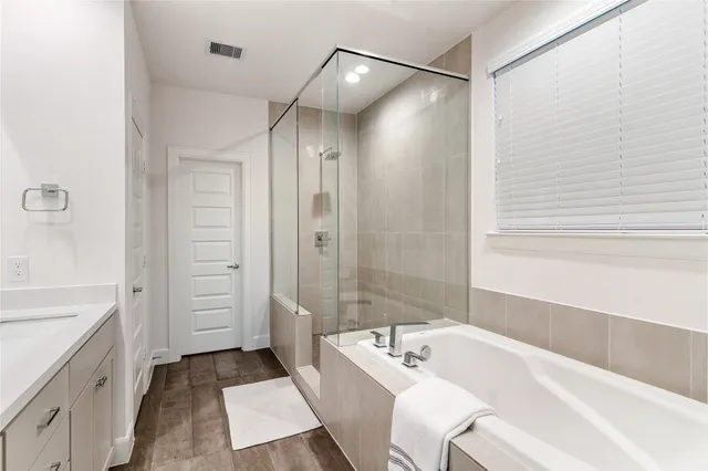 a bathroom with a tub sink and mirror