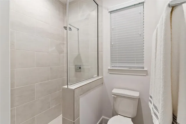 a white toilet sitting next to a shower