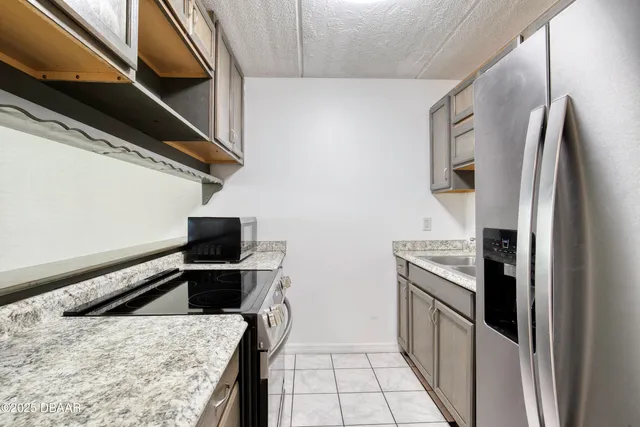a kitchen with stainless steel appliances granite countertop a refrigerator and a stove
