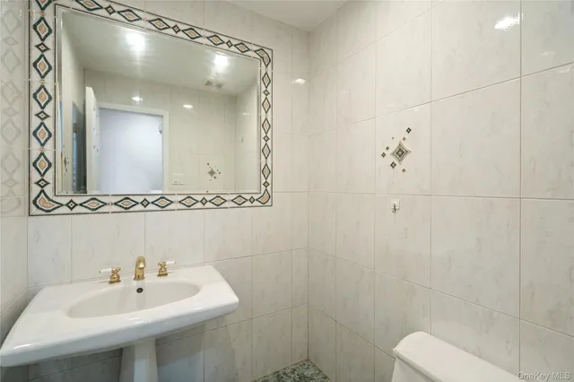 a bathroom with a granite countertop sink a toilet and bathtub