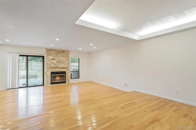 a view of an empty room with a fireplace and a window