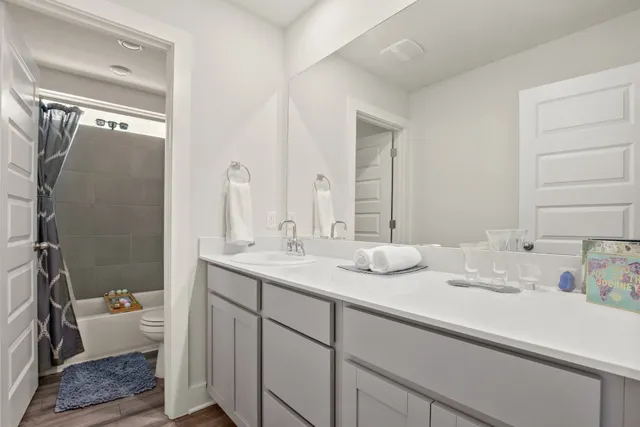 a en suite bathroom with a double vanity sink and a mirror