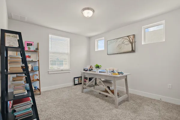 a view of a workspace with furniture and a window
