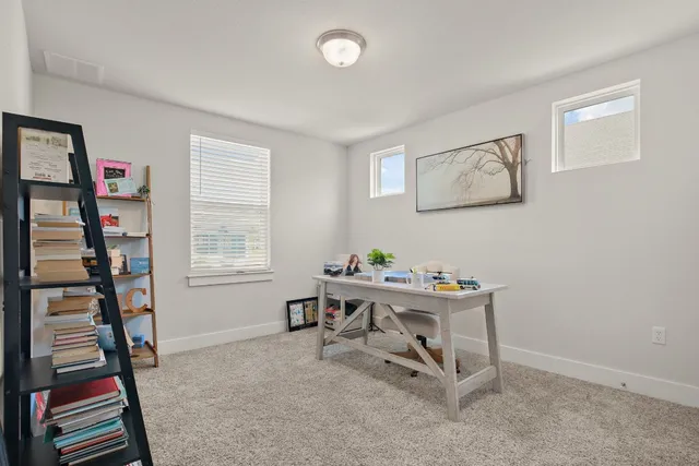 a view of a workspace with furniture and a window