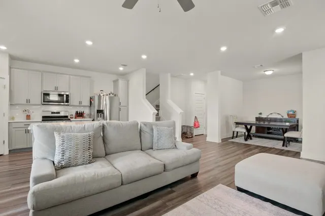 a living room with furniture kitchen area and a kitchen view