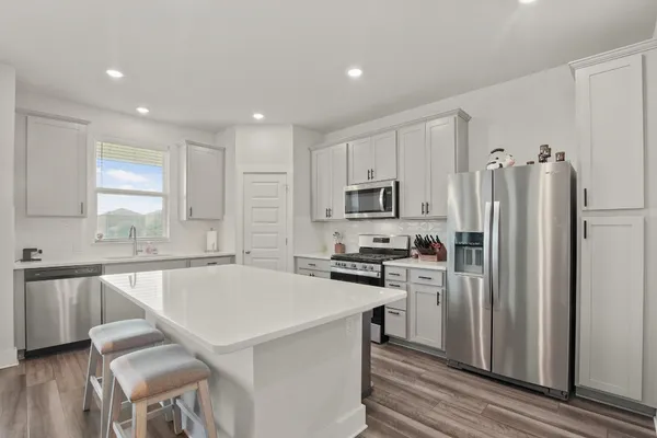a kitchen with stainless steel appliances a refrigerator stove microwave and cabinets