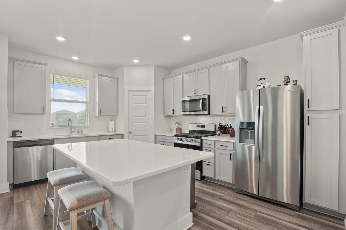 7507 Grand Linden Way Austin, TX 78744 - Photo 8 of 26 a kitchen with stainless steel appliances a refrigerator stove microwave and cabinets