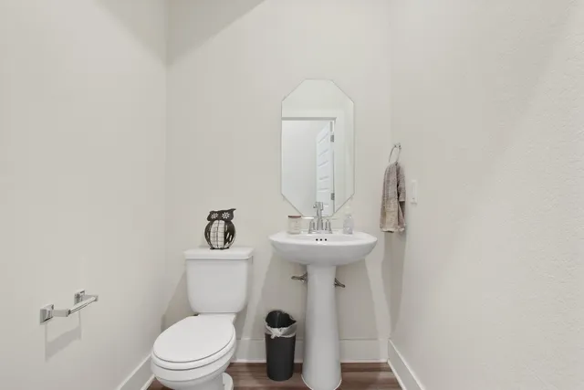 a bathroom with a sink a toilet and a mirror