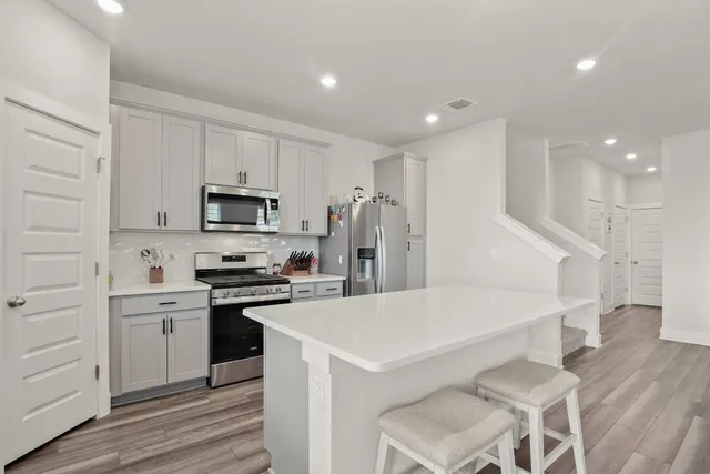 a kitchen with white cabinets and stainless steel appliances