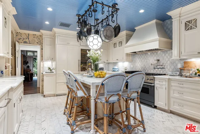 a kitchen with stainless steel appliances kitchen island granite countertop a table chairs sink and cabinets