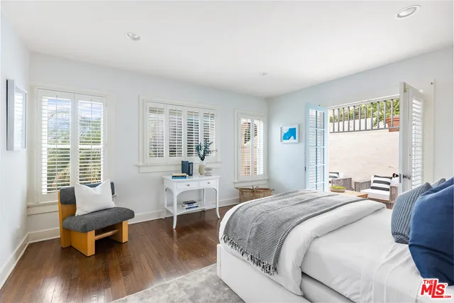 a spacious bedroom with a bed and wooden floor