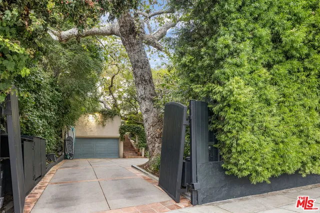 a view of a patio with couches table and chairs under an umbrella with a fire pit