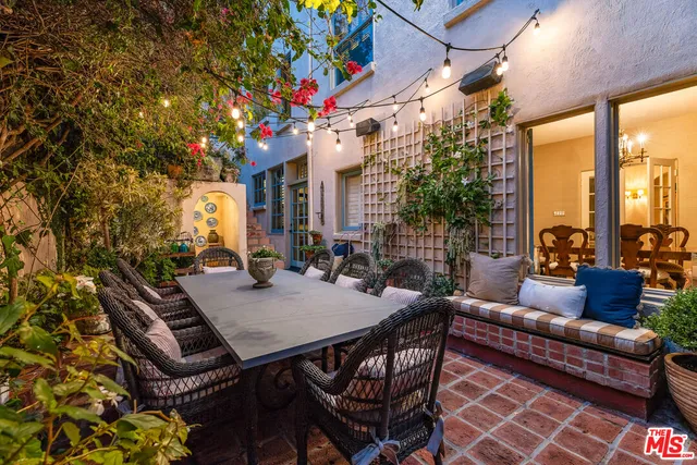 a view of a backyard with plants and large trees