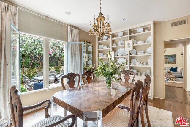 a dining room with furniture a chandelier and wooden floor