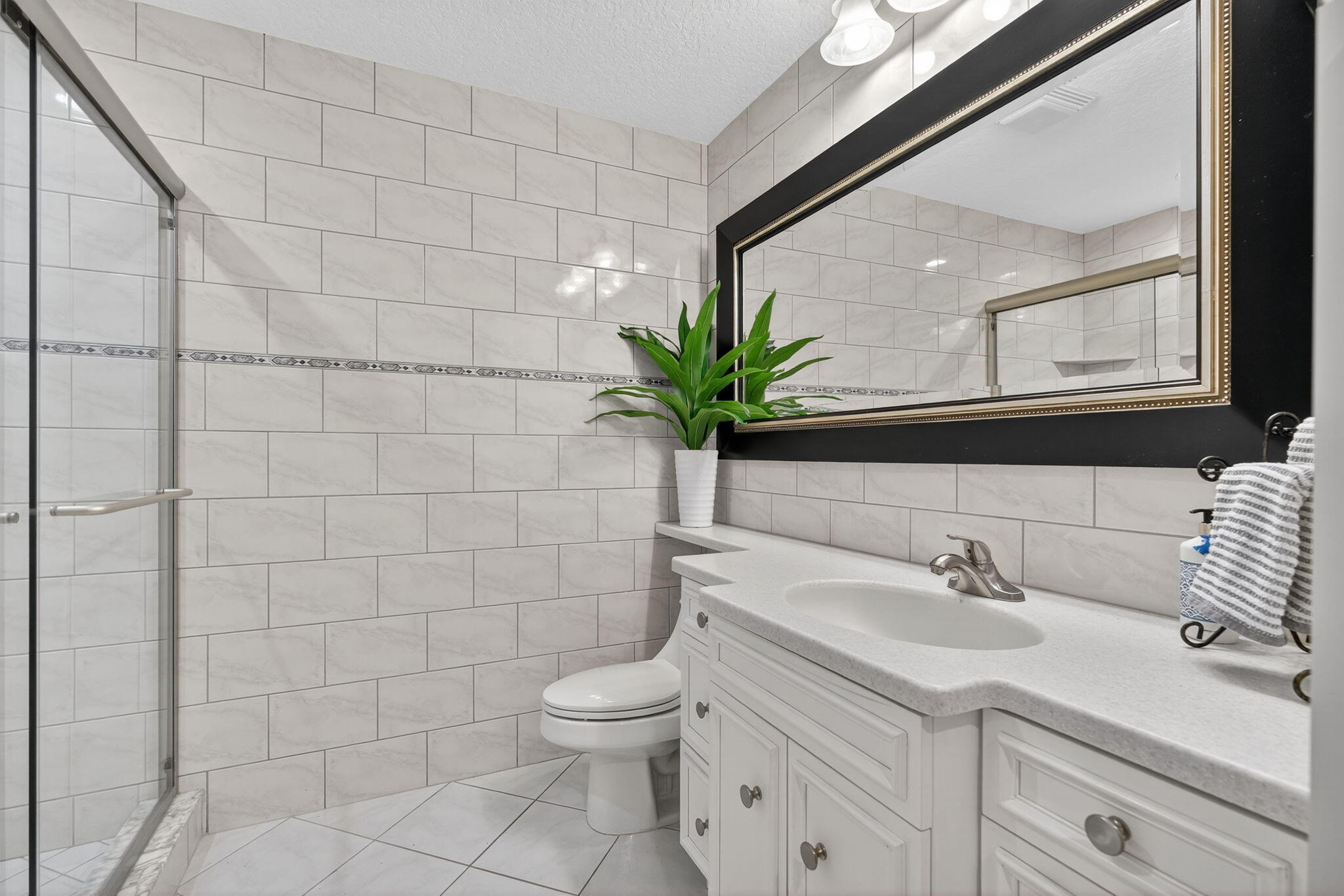 121 Landward Drive Jupiter, FL 33477 - Photo 42 of 80 a bathroom with a sink a mirror and a toilet