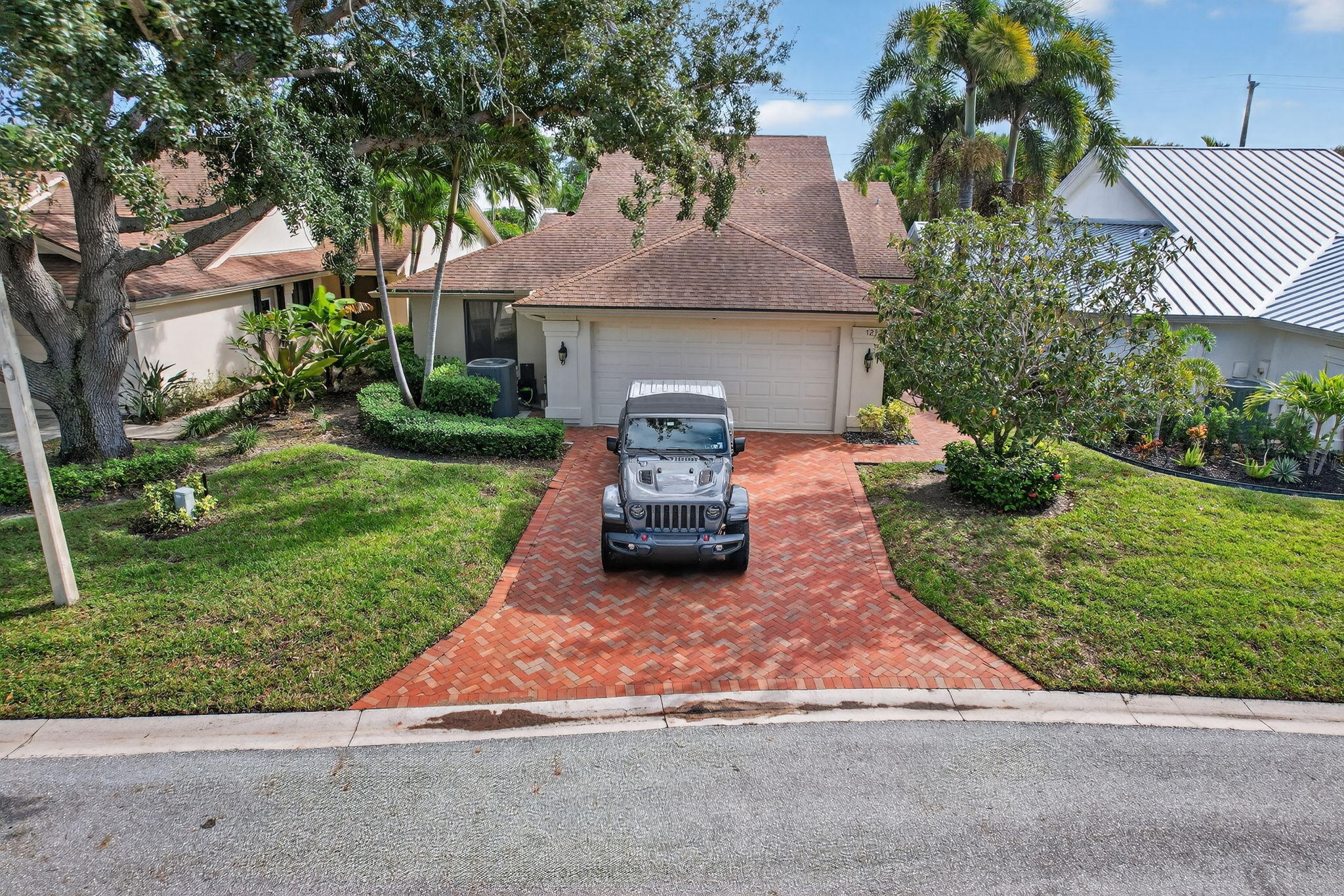 121 Landward Drive Jupiter, FL 33477 - Photo 61 of 80 a front view of a house with a yard and garage