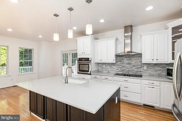 a kitchen with stainless steel appliances kitchen island granite countertop a kitchen island hardwood floor sink and stove