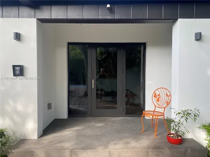 a white house that has a tree in front of it