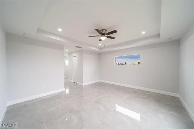 an empty room with a ceiling fan and a window