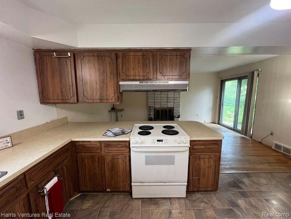 28482 Sutherland Avenue Warren, MI 48088 - Photo 9 of 25 Kitchen area with wood-finish cabinetry, light-toned countertops, and a white electric range