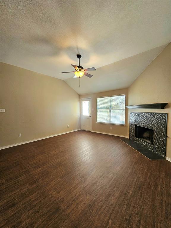 14224 Polo Ranch Street Fort Worth, TX 76052 - Photo 6 of 35 an empty room with wooden floor fireplace and windows